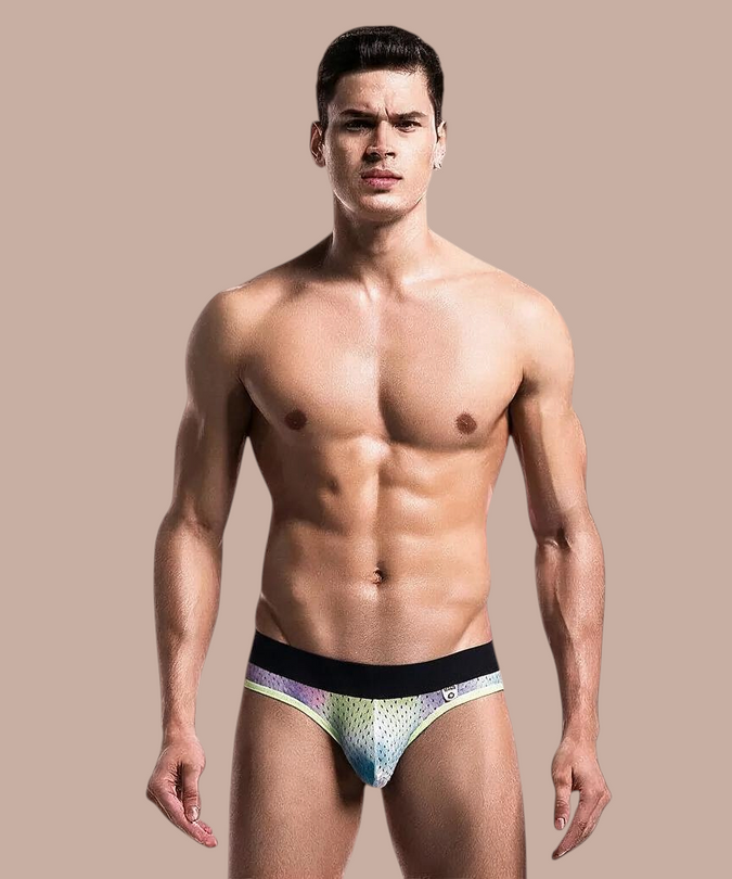 Pleasurements MOB jockstrap met kleurrijke print, zwarte tailleband en contrasterende bies op een model.