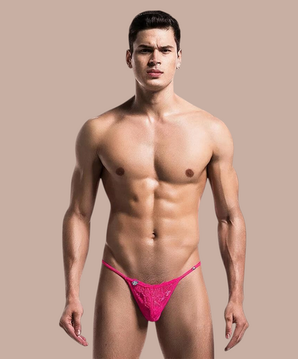 Mob – Pink Lace Thong Pleasurements MOB roze kanten herentang met minimalistisch design gedragen door een model