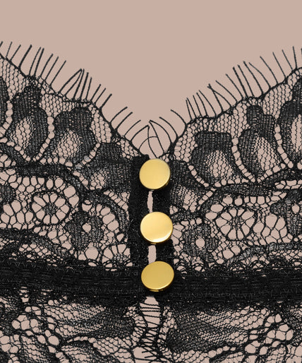 Maison Close/Scandale – Inspiration Divine Open Back Lace Thong Body Black Inspiration Divine black Open Back Lace Thong Body with sheer floral lace and a gold-tone cross at the collar, front view on model.