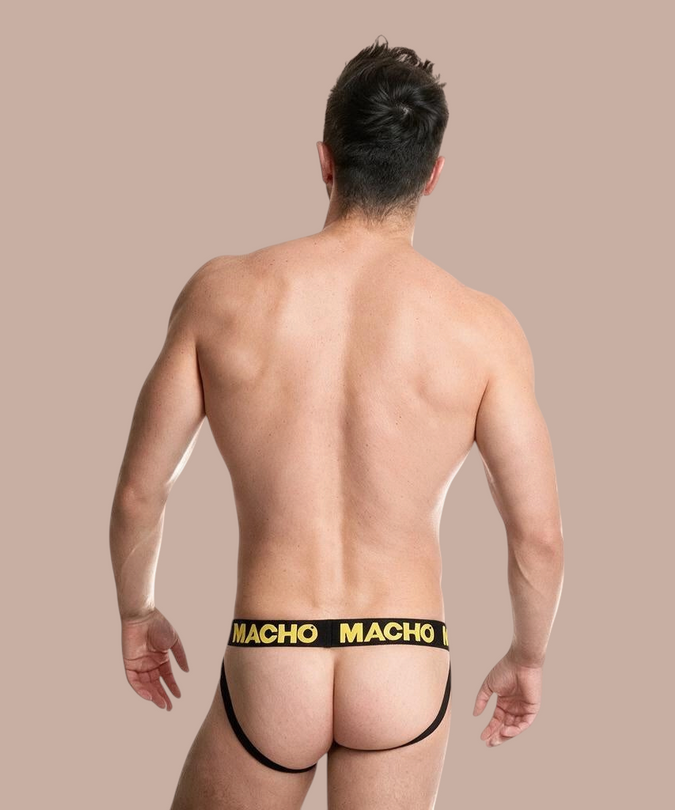 Pleasurements Macho MX25A jockstrap in geel met zwarte elastische tailleband gedragen door een man van achteren