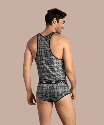 Anais Men – Balance Top S Pleasurements Anais Men Balance Top in grijs met ruitpatroon, gedragen door een glimlachend model.