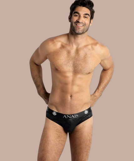 Anais Men – Electro Slip S Model draagt zwarte Anais Men Electro Slip herenonderbroek met merklogo op de tailleband van Pleasurements