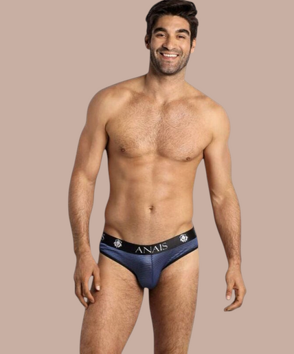 Anais Men – Naval Slip S Pleasurements Anais Men Naval Slip in blauw met een elastische tailleband gedragen door een glimlachend model
