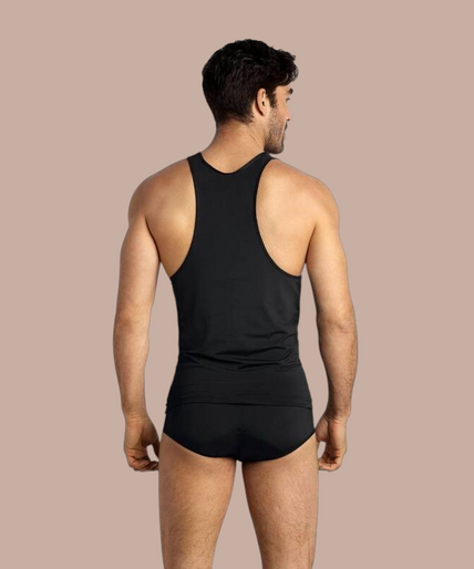 Anais Men – Petrol Top | Premium Men’s Underwear Pleasurements Anais Men Petrol top in zwart gedragen door een glimlachend model als onderdeel van premium ondermode.