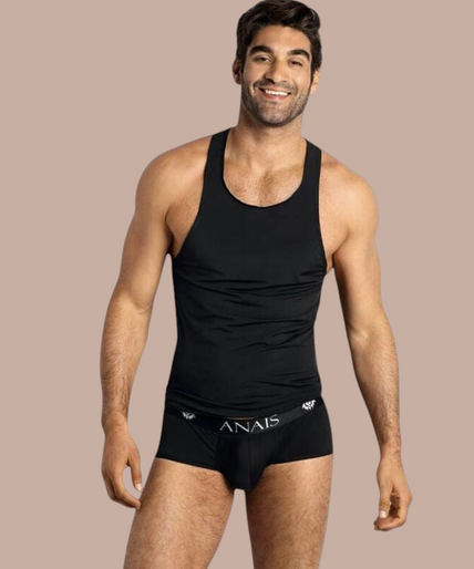 Anais Men – Petrol Top | Premium Men’s Underwear Pleasurements Anais Men Petrol top in zwart gedragen door een glimlachend model als onderdeel van premium ondermode.