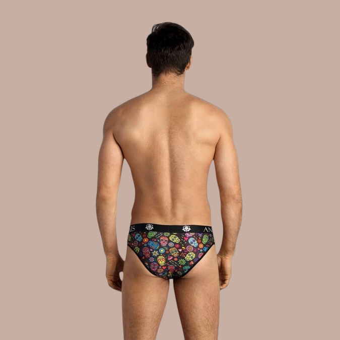 Achterkant van de Anais Men Mexico Slip met kleurrijke schedelprint, gedragen door een model van Pleasurements.