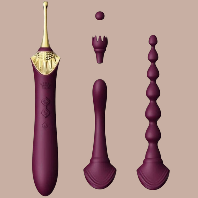 Pleasurements Zalo Bess 2 paarse clitorisstimulator van siliconen met verwisselbare opzetstukken en gouden details.