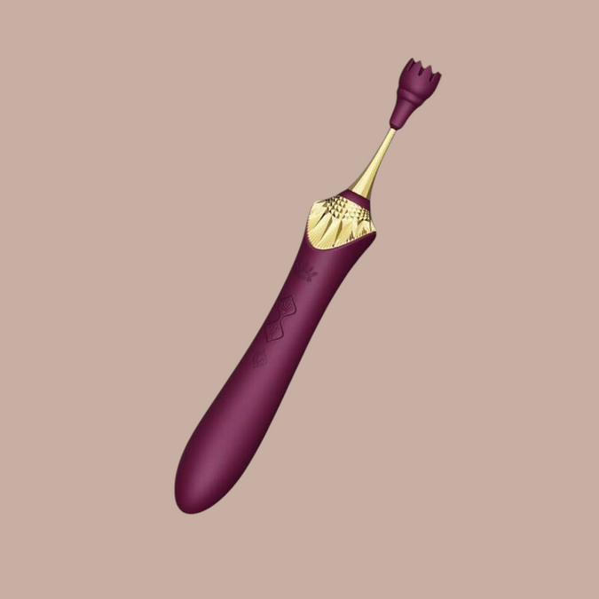 Pleasurements Zalo Bess 2 paarse clitorisstimulator van siliconen met gouden details en verwisselbare opzetstukken.