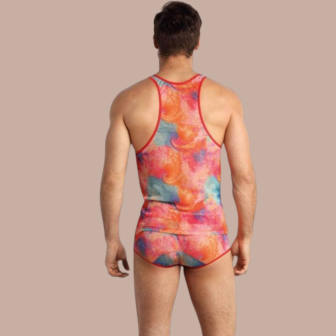 Pleasurements Anais Men Falcon Top met kleurrijk abstract patroon en rode bies, gedragen door een man van achteren.