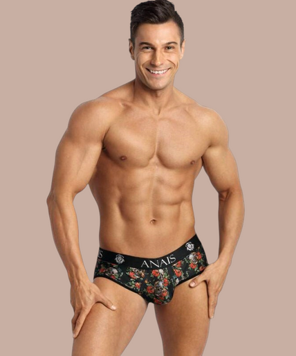 Anais Men – Power Jock Bikini L Pleasurements Anais Men Power Jock Bikini met bloemenprint en zwarte tailleband gedragen door een gespierd model