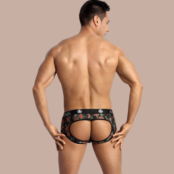 Pleasurements Anais Men Power Jock Bikini met bloemenprint en open achterkant gedragen door een man