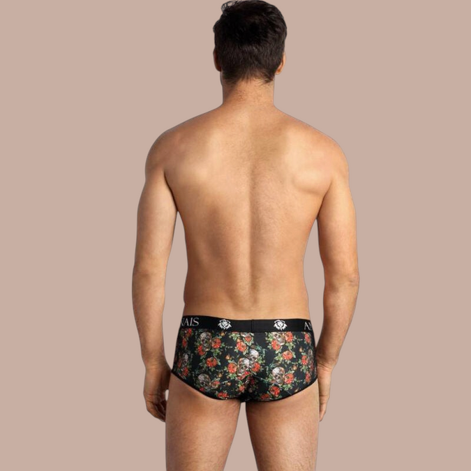 Pleasurements Anais Men Power Brief met zwarte onderbroek met schedel- en rozenprint op een man van achteren gezien.