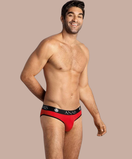 Anais Men – Soul Slip S Pleasurements Anais Men Soul Slip in rood met zwarte tailleband gedragen door een glimlachend model