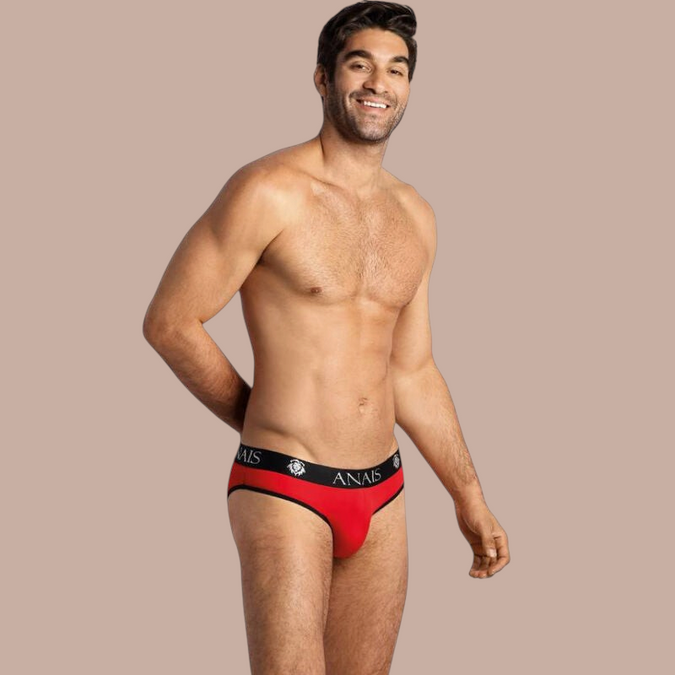 Pleasurements Anais Men Soul Slip in rood met zwarte tailleband gedragen door een glimlachend model