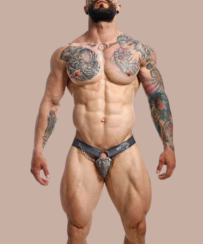 Pleasurements Mob Dngeon Snap jockstrap in grijs leer en metaal met kettingdetails gedragen door een gespierd model
