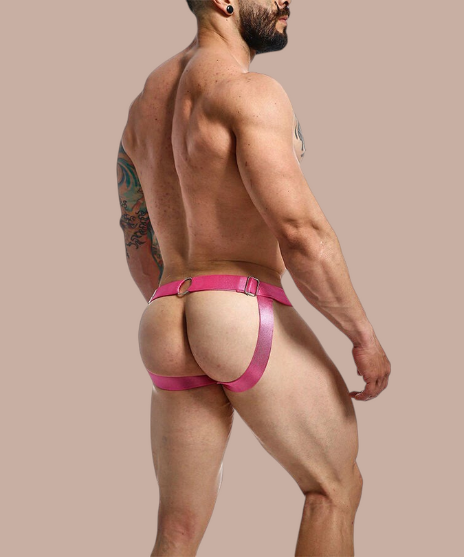 Pleasurements Mob Dngeon jockstrap in roze leer en metaal gedragen door een man voor een sensuele uitstraling