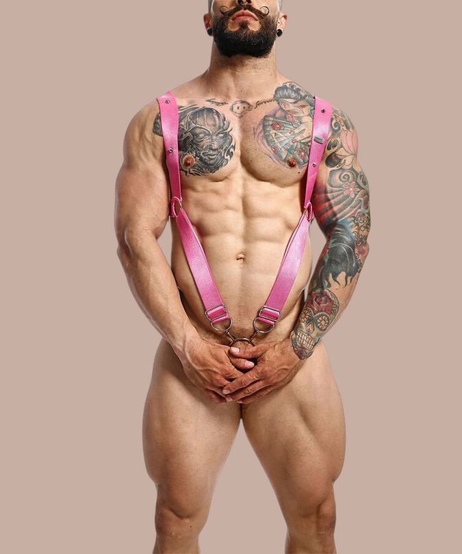 Pleasurements Mob Dngeon roze leren harnas met metalen ringen gedragen door een gespierd getatoeëerd model