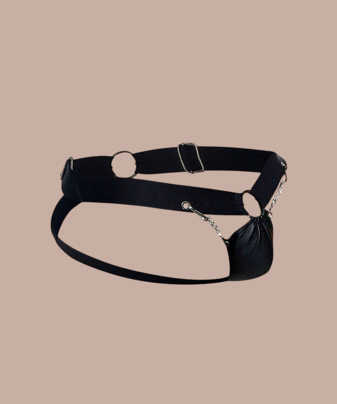 Pleasurements Mob Dngeon zwarte leren jockstrap met metalen kettingen en ringen voor een sensueel silhouet.