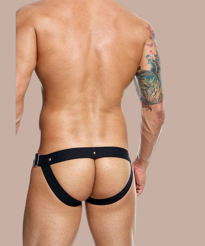 Pleasurements Mob Dngeon jockstrap in zwart leer en metaal, gedragen op de rug voor een sensuele uitstraling.