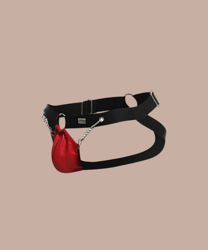 Pleasurements Mob Dngeon rode jockstrap van leer met metalen kettingen en zwarte banden voor een sensuele uitstraling.