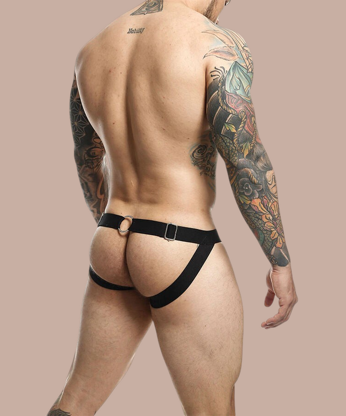 Pleasurements Mob Dngeon rode jockstrap met metalen kettingdetails en lederen accenten gedragen door een man