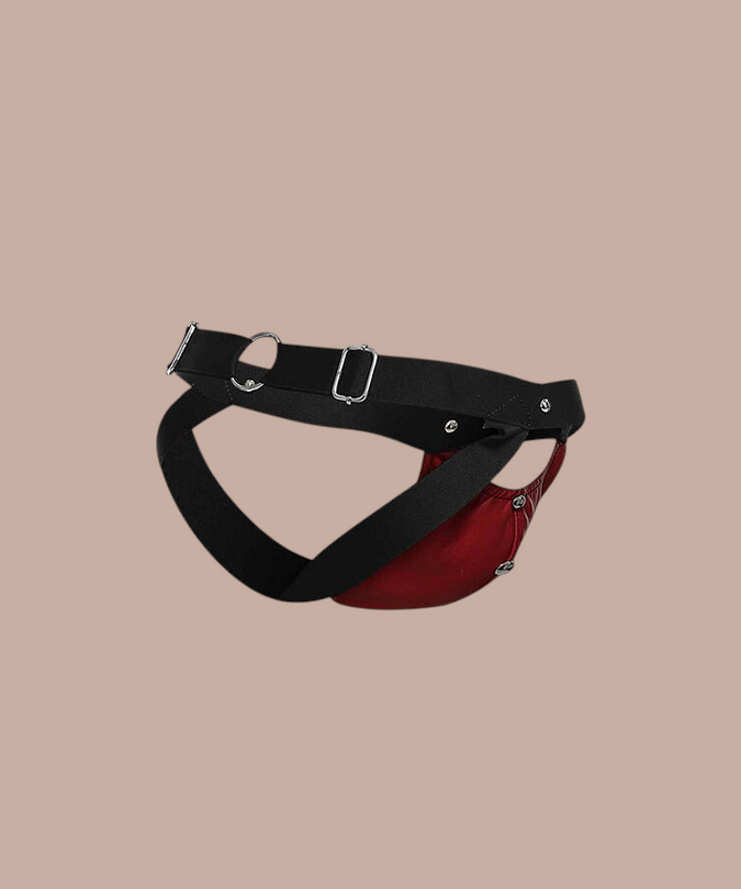 Pleasurements Mob Dngeon jockstrap in rood leer en metaal met zwarte banden voor een sensueel en elegant design.