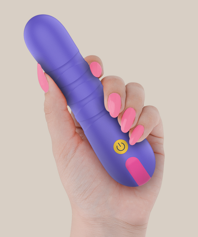 Pleasurements Stella paarse siliconen vibrator met stuwende functie vastgehouden in een hand