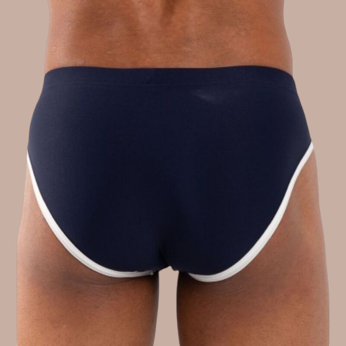 Pleasurements Burn 020 marineblauwe slip met witte bies, gedragen op de rug gezien voor een verfijnde uitstraling.