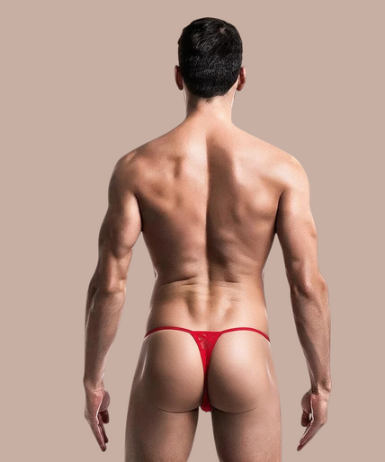 Model draagt een rode kanten MOB thong van Pleasurements met een minimalistisch en sensueel ontwerp.