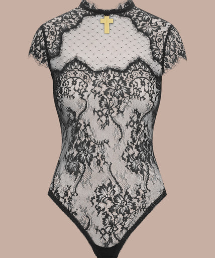 Inspiration Divine black Open Back Lace Thong Body with sheer floral lace and a gold-tone cross at the collar, front view on model.