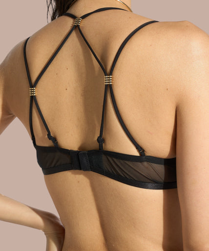 Pleasurements Atelier Amour Sans Détour zwarte half-cup bh met verfijnd kant en gouden accenten op een model