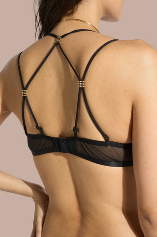 Pleasurements Atelier Amour Sans Détour zwarte half-cup bh met verfijnd kant en gouden accenten op een model