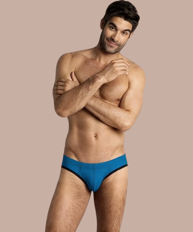 Model draagt Pleasurements BURN 018 blauwe slip met zwarte accenten voor een stijlvolle, mannelijke uitstraling.