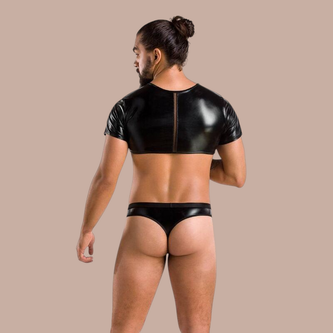 Man draagt Pleasurements Passion 057 Peter zwarte set bestaande uit een cropped top en string in glanzend materiaal.