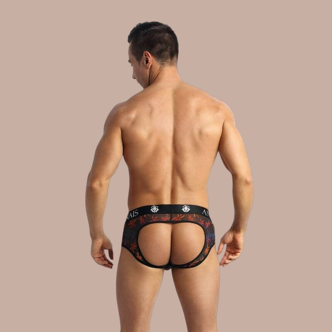 Pleasurements Anais Men Chill Jock Bikini met open achterkant en kleurrijk palmbladpatroon op zwarte mesh stof