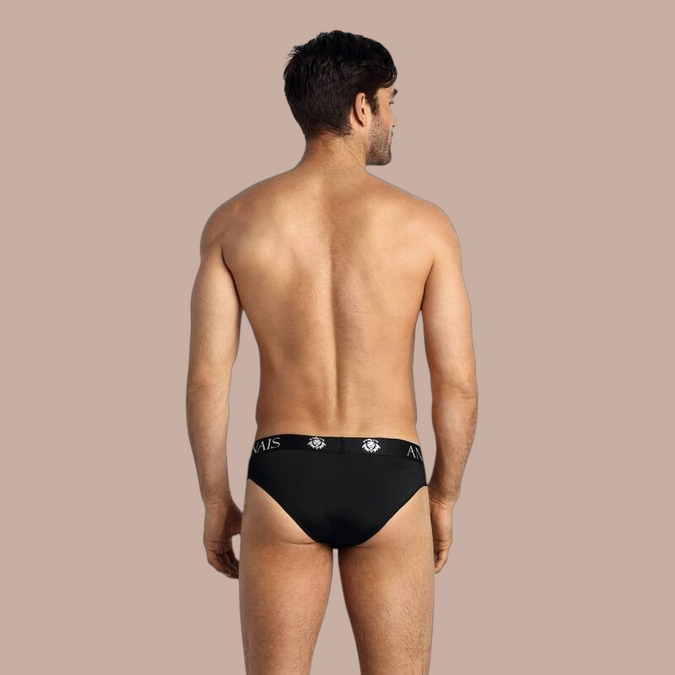 Pleasurements Anais Men Petrol Slip in zwart met een elastische tailleband met logo, gedragen door een man van achteren