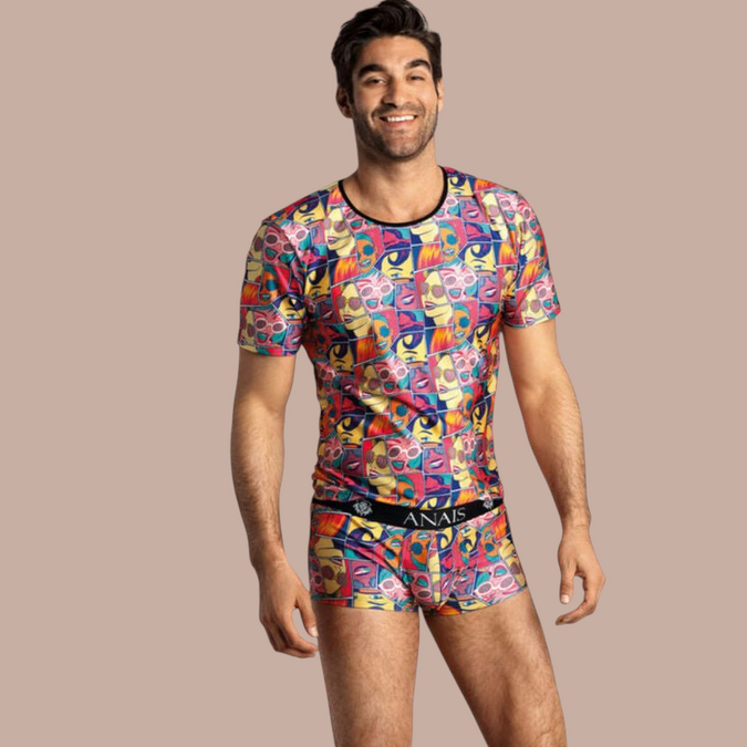 Pleasurements Anais Men Comics T-shirt met kleurrijke stripboekprint gedragen door een glimlachend model