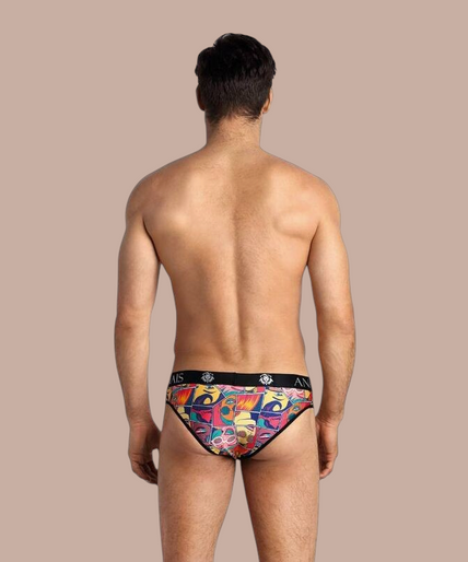 Pleasurements Anais Men Comics Slip met kleurrijke stripboekprint en zwarte tailleband gedragen door een model