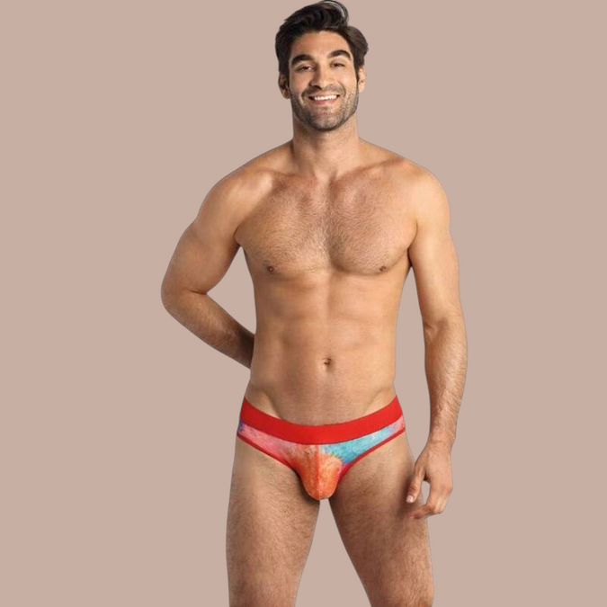 Pleasurements Anais Men Falcon slip met kleurrijk tie-dye patroon en rode tailleband gedragen door een model