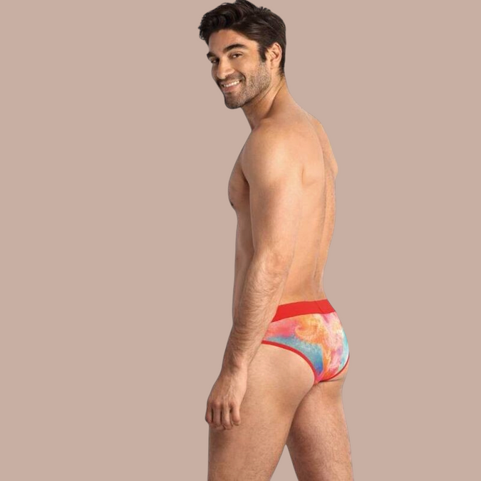 Pleasurements Anais Men Falcon slip met kleurrijke print en rode tailleband gedragen door een model van opzij