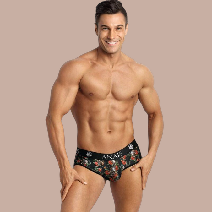 Pleasurements Anais Men Power Jock Bikini met bloemenprint en zwarte tailleband gedragen door een gespierd model