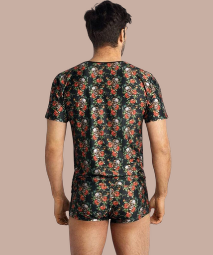 Pleasurements Anais Men Power T-shirt met zwart, rood en wit schedel- en rozenpatroon gedragen door een lachend model
