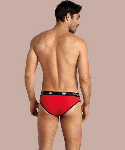 Pleasurements Anais Men Soul Slip in rood met zwarte tailleband gedragen door een glimlachend model