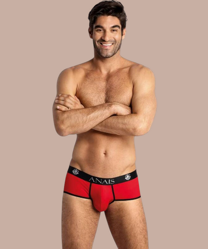 Pleasurements Anais Men Soul Brief in rood met zwarte tailleband en logo, gedragen door een glimlachend model.