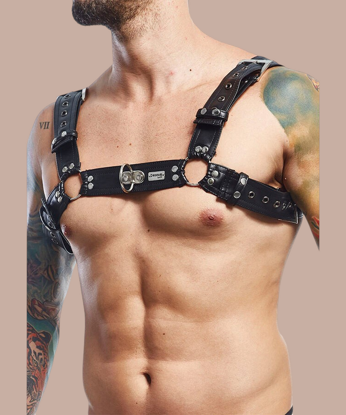 Pleasurements Mob Dngeon zwarte lederen en metalen harnasgordel gedragen door een man met tatoeages