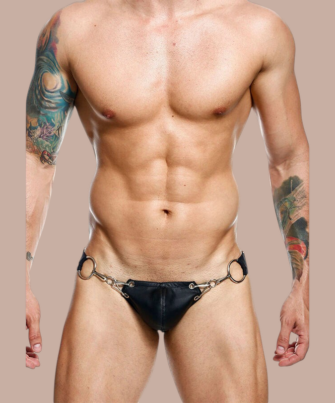 Pleasurements Mob Dngeon jockstrap in zwart leer met metalen ringen gedragen door een gespierd model