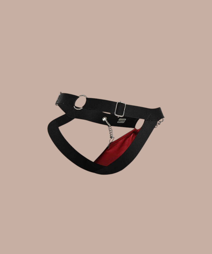 Pleasurements Mob Dngeon rode jockstrap met zwarte banden en zilverkleurige kettingdetails voor een sensuele look.