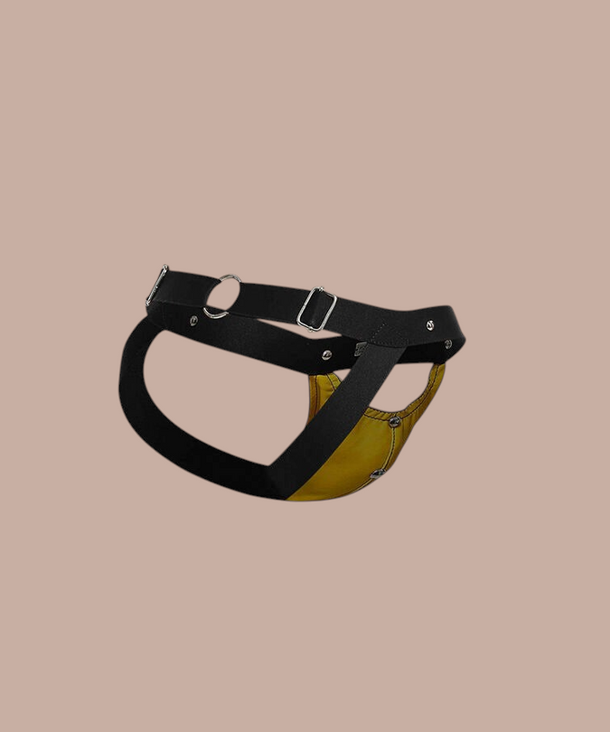 Pleasurements Mob Dngeon jockstrap in geel leer met zwarte banden en metalen ringen voor een sensuele uitstraling.