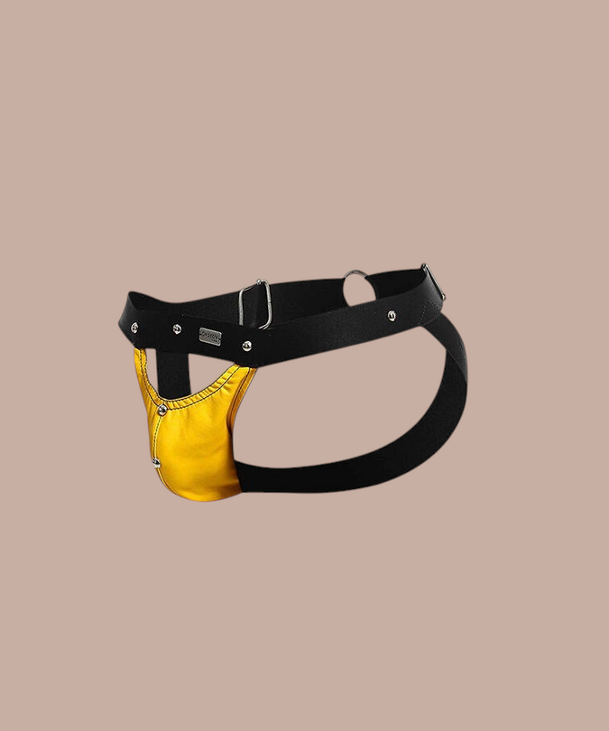Pleasurements Mob Dngeon jockstrap in geel leer en metaal met zwarte banden voor een sensuele en elegante uitstraling.