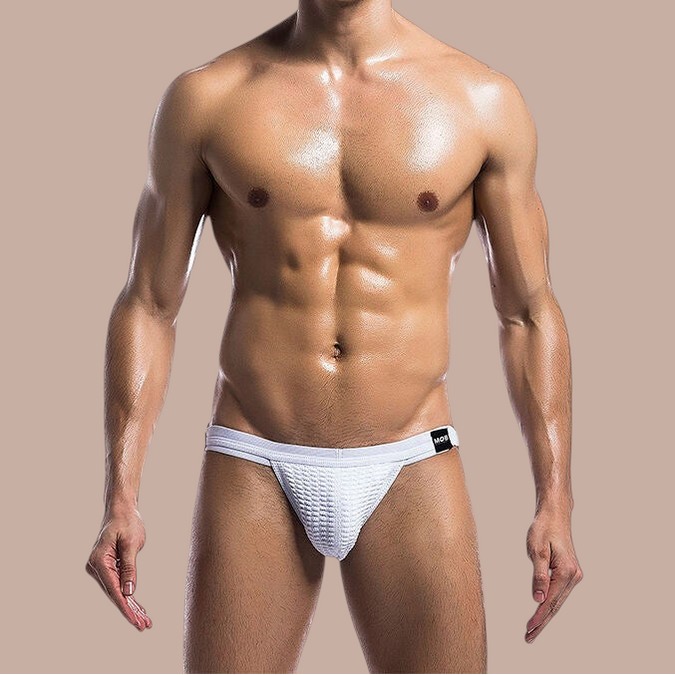 Pleasurements Mob witte fetish jockstrap zwembroek met textuur gedragen door een gespierd model